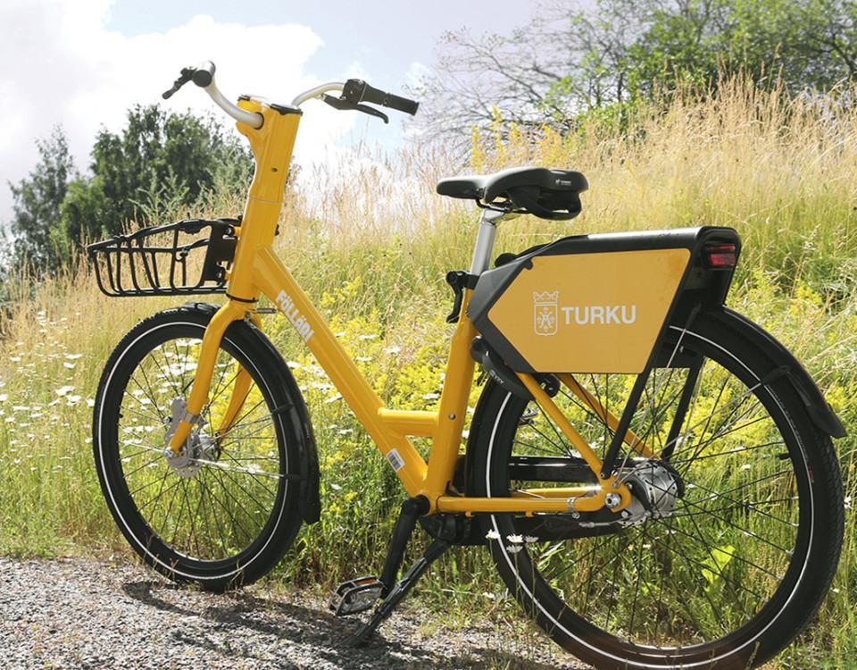 En gul cykel med korg vid sidan av en grusväg.