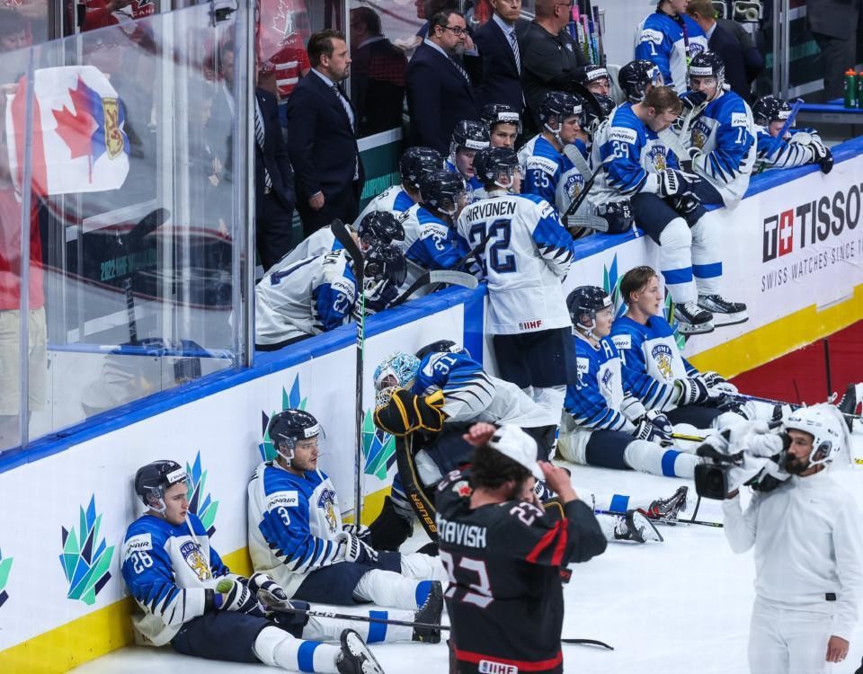 bersvikna ishockeyspelare sitter lutade mot sargkanten