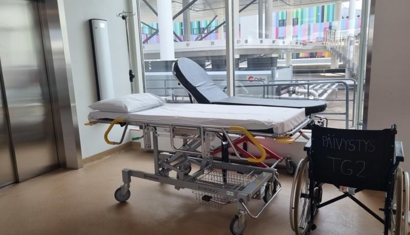 patientbritsar i en sjukhuskorridor och en rullstol