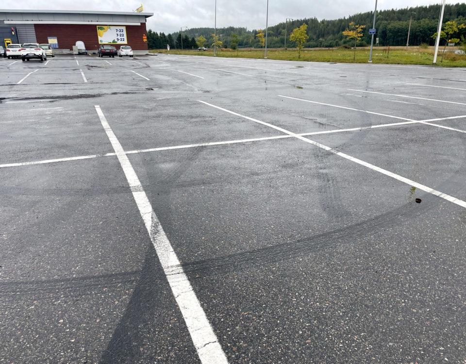parkeringsplats vid affär med svarta spår efter däck