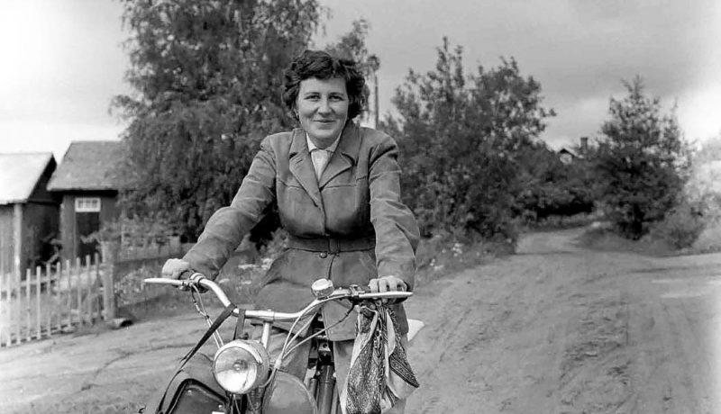 Ett svartvitt foto på en kvinna på moped.