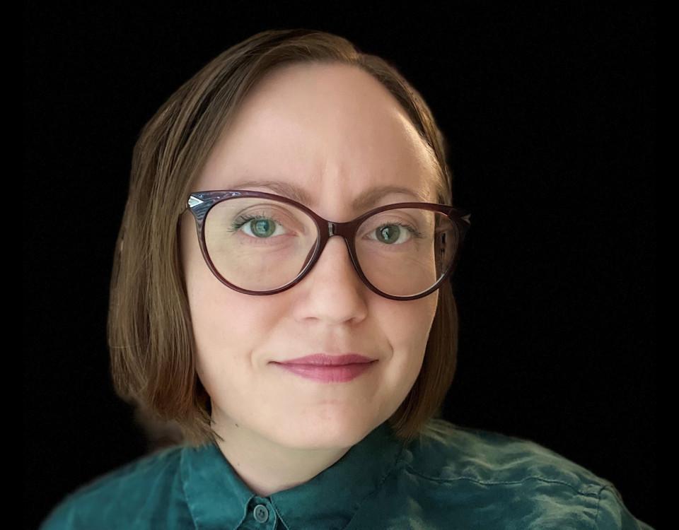 Kvinna med glasögon och grön skjorta