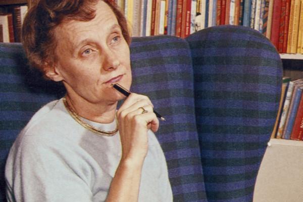 Kvinna sitter i fåtölj och håller en penna i handen