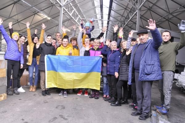 en grupp människor bakom Ukrainas flagga