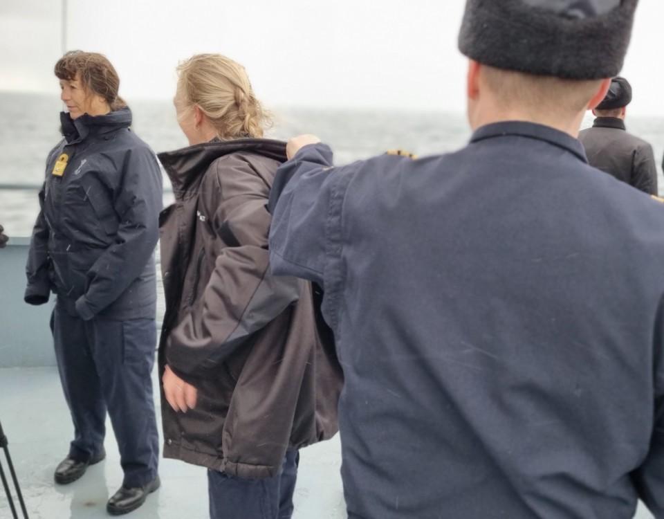 En finländsk officer ger sin jacka till en holländsk kollega.