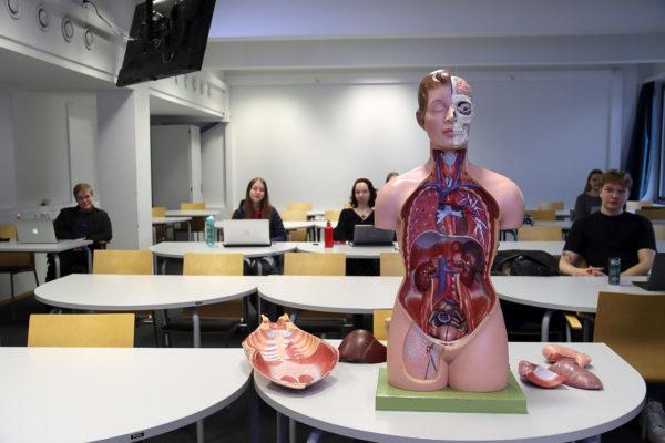 Studerande med en docka som visar människans inre organ framför sig.