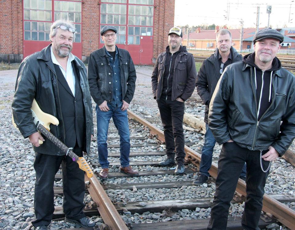 Fem män står vid en järnvägsräls.
