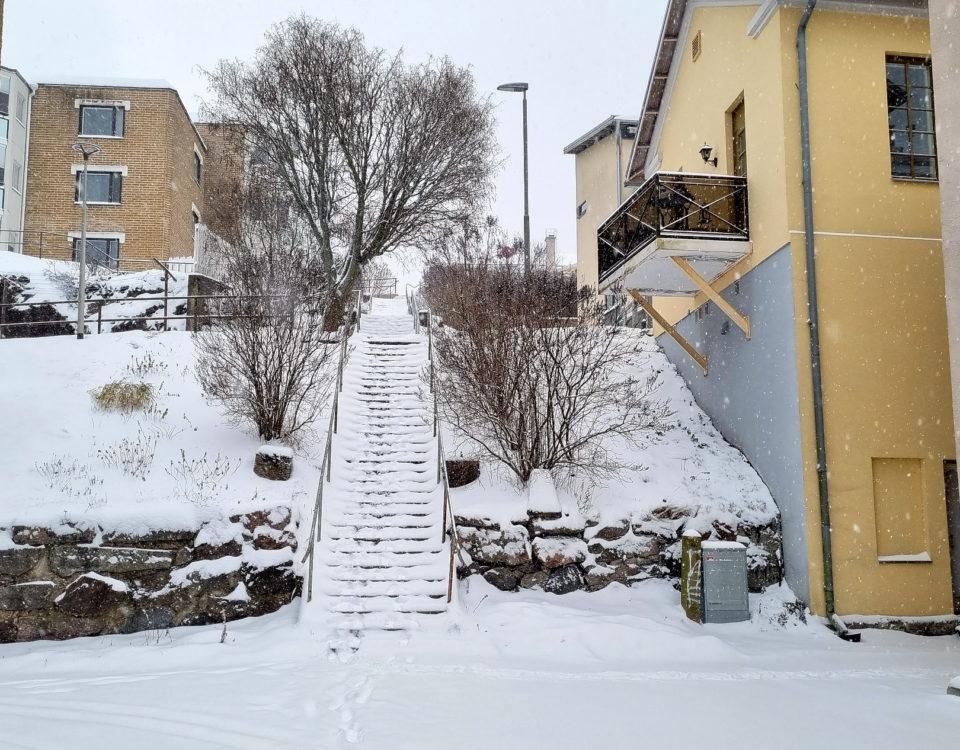 Snötäckta trappor mellan bostadshus