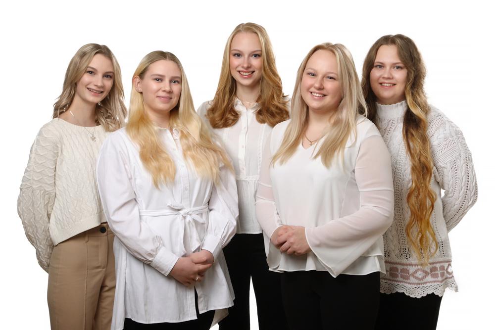 fem unga kvinnor med leenden och vita blusar