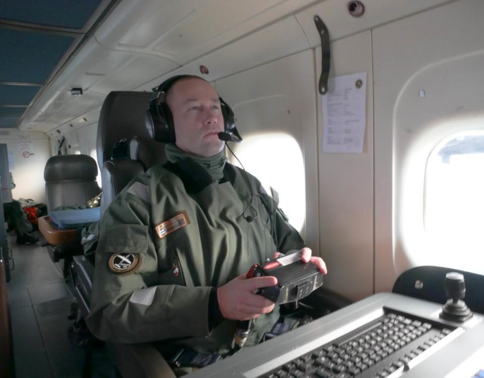 En gränsbevakare sitter i ett flygplan och tittar på en skärm