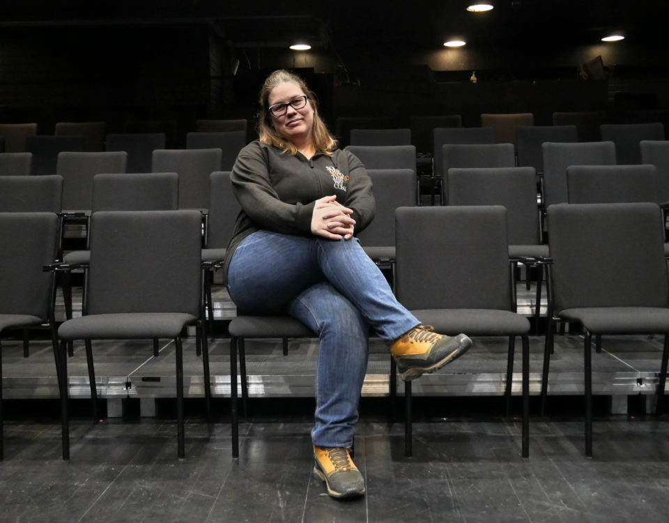 En kvinna sitter i en tom teatersalong