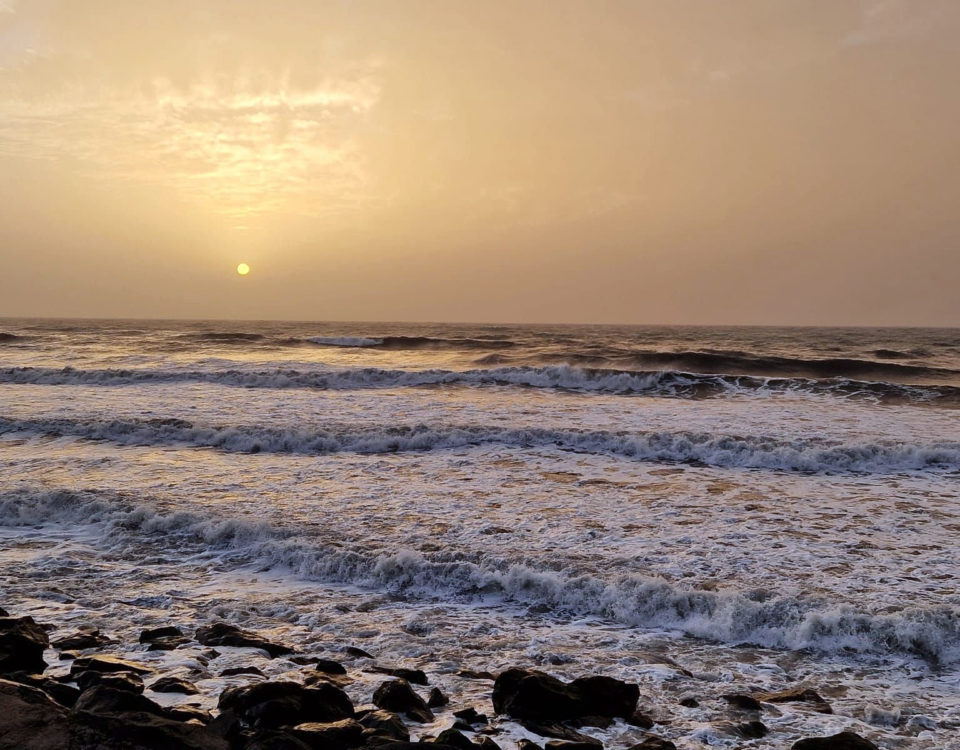 gulaktig solnedgång över hav med vågor