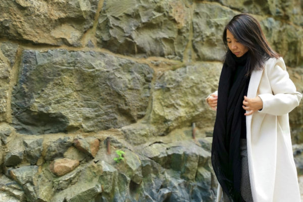 En kvinna framför en stenmur.