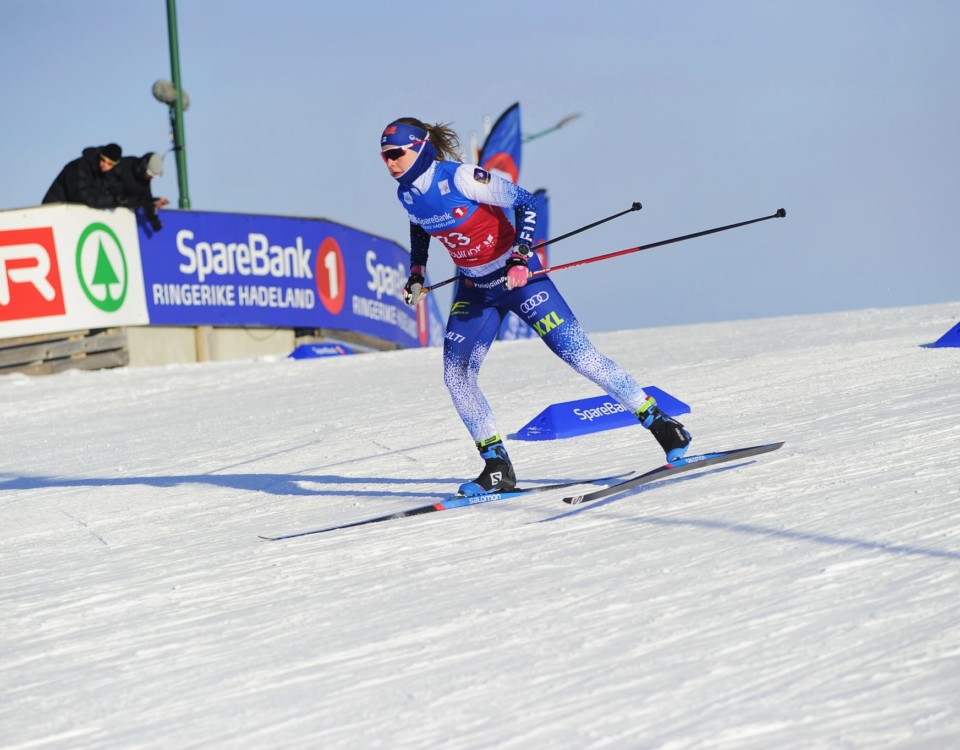 En ung kvinna på skidor i en tävling.