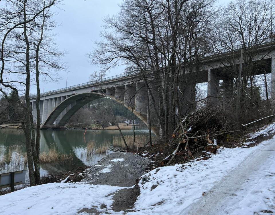 Stor bro över ett vattendrag i snöigt landskap