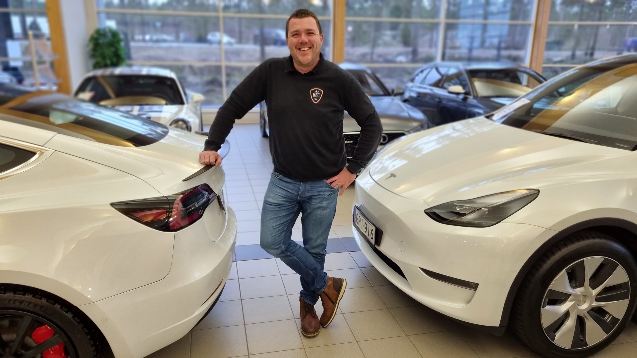 Niklas Nylund mellan två Tesla i sin bilaffär.