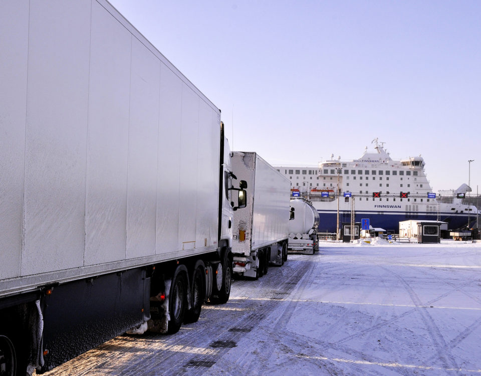 Lastbilar och långtradare står i kö för att få köra ombord på fartyg