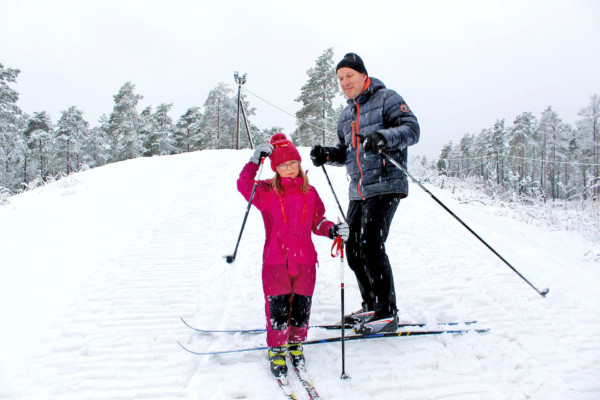 Ett barn och en vuxen på skidor
