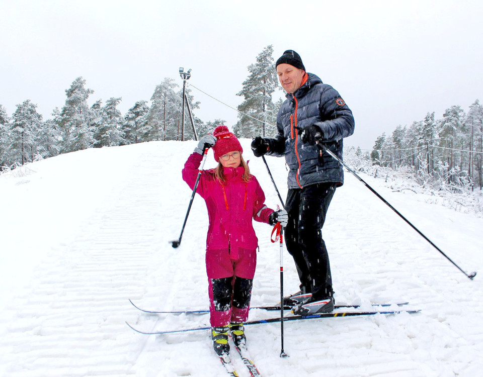 Ett barn och en vuxen på skidor