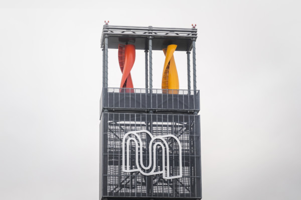 En pelare med köpcentrumet Myllys logotyp och vindturbiner.