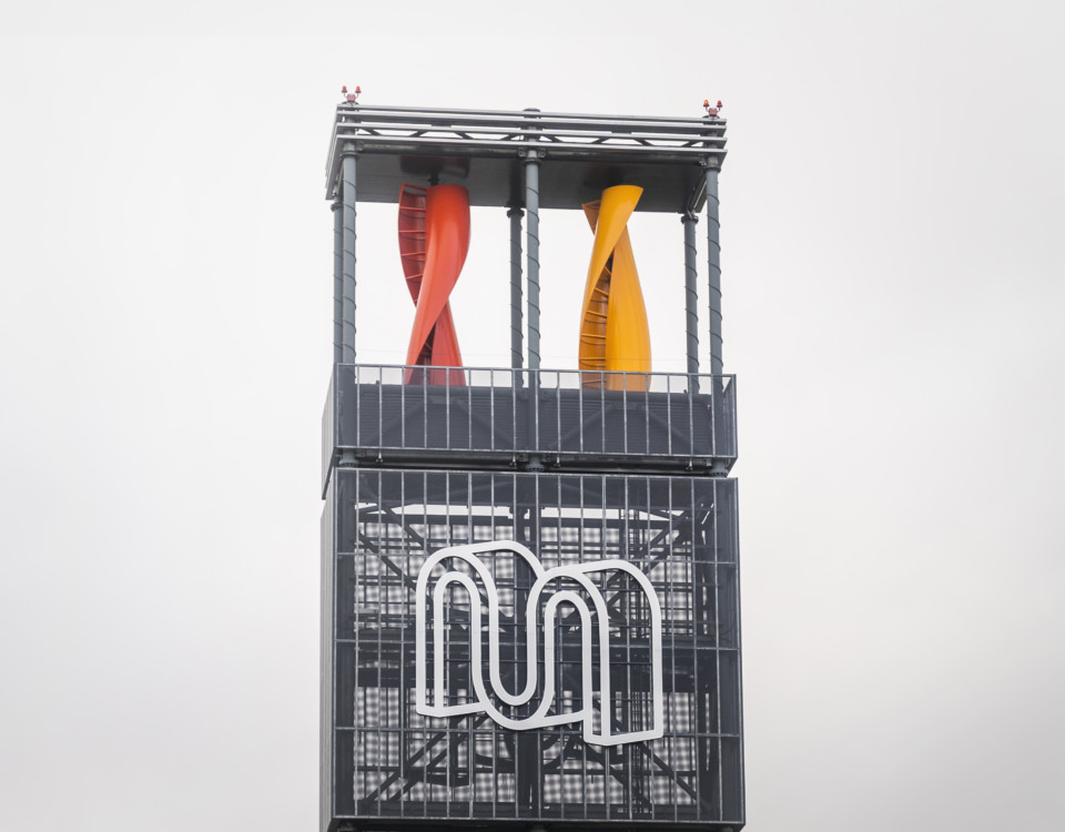 En pelare med köpcentrumet Myllys logotyp och vindturbiner.