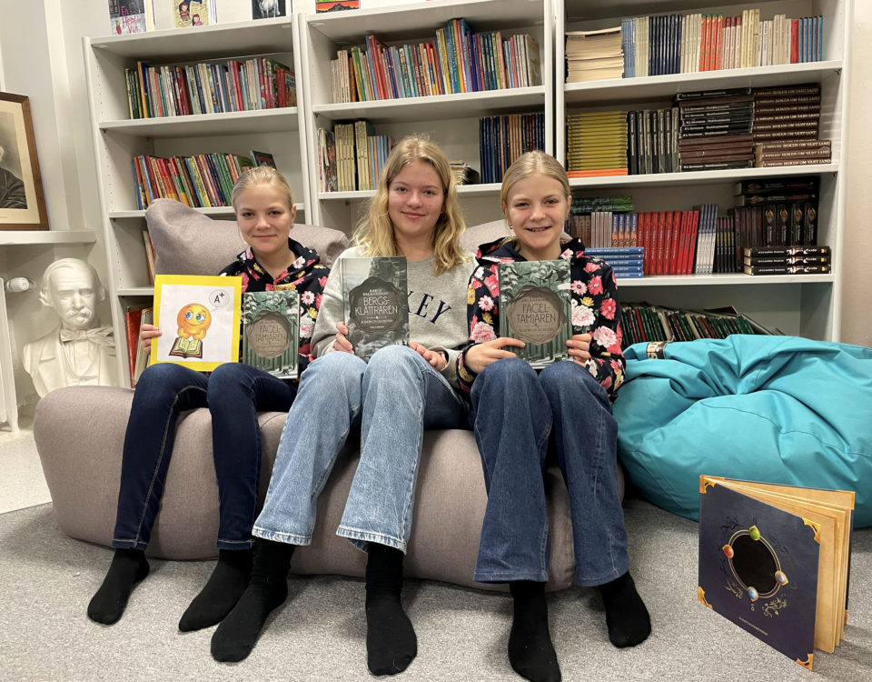 tre flickor med böcker i händerna