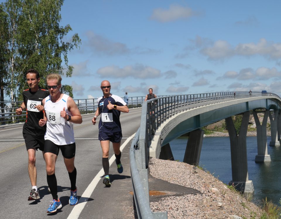 Tre personer springer över Lövö bro
