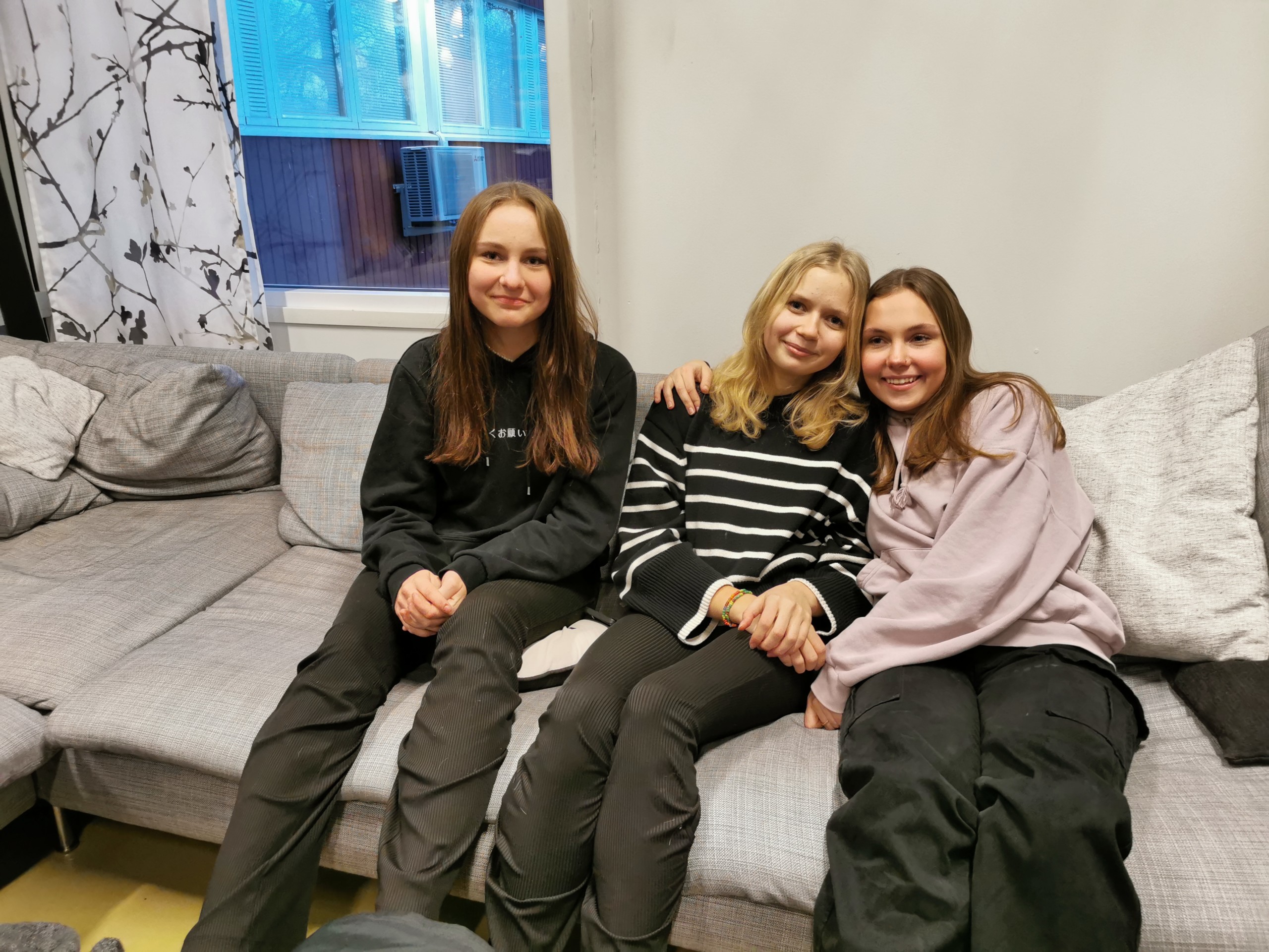 Tre flickor i en soffa