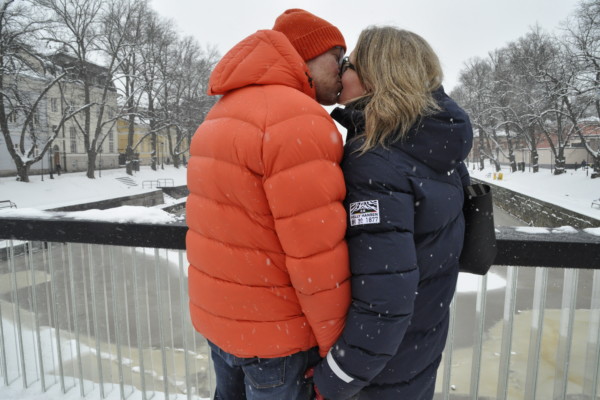 ett par kysser varndra på en bro