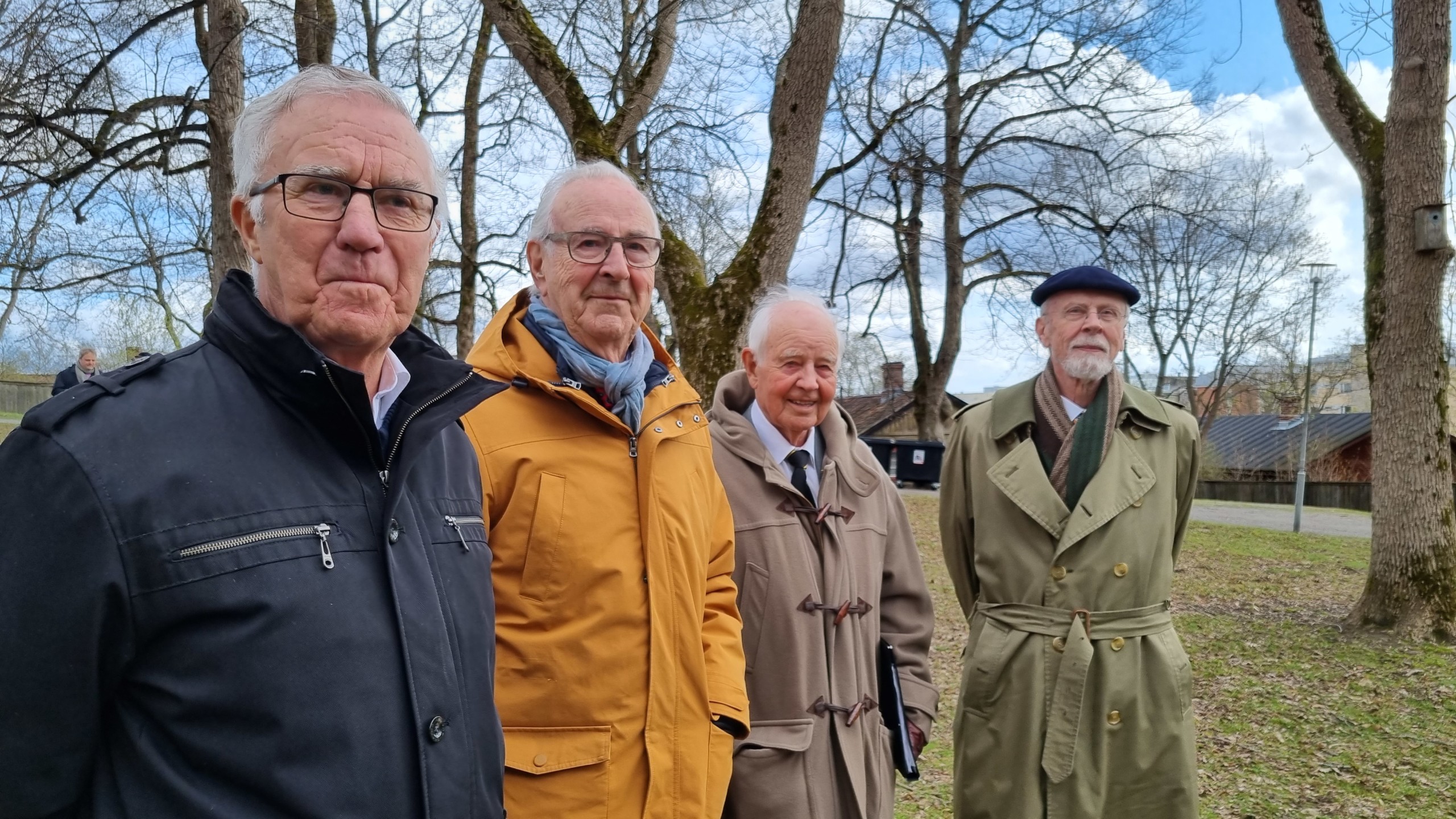 fyra stiliga äldre herrar i en park