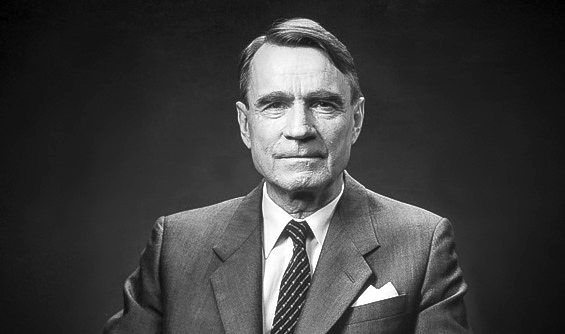 Ett svartvitt fotografi på en man i kostym.