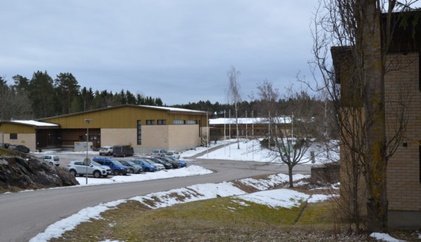 en skolbyggnad med en parkeringsplats