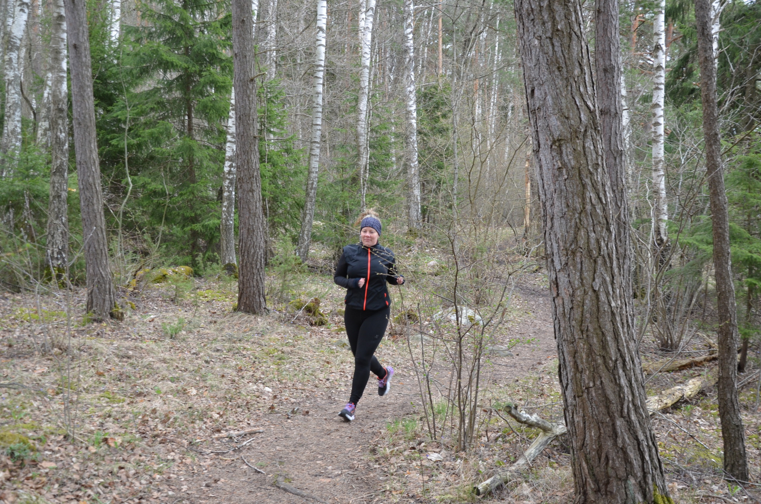 en kvinna som springer i skogen