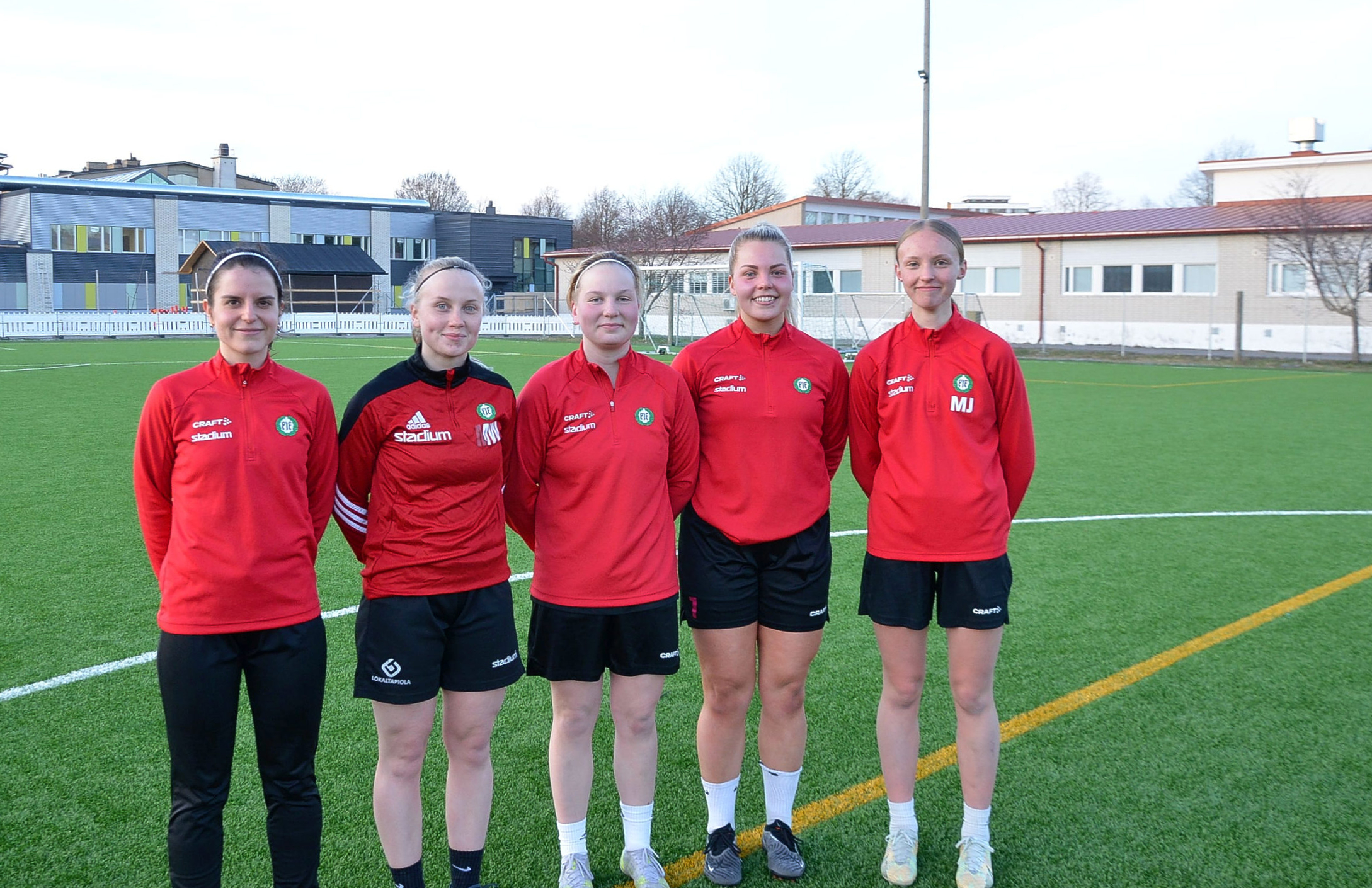 fem kvinnliga fotbollsspelare står bredvid varandra