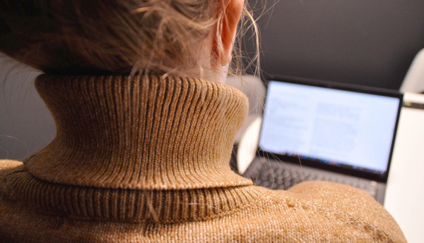 en kvinna sitter framför en dator