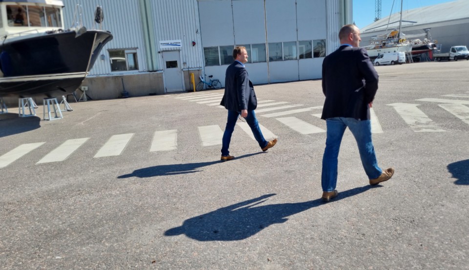 Tvä män vandrar på fabrik.