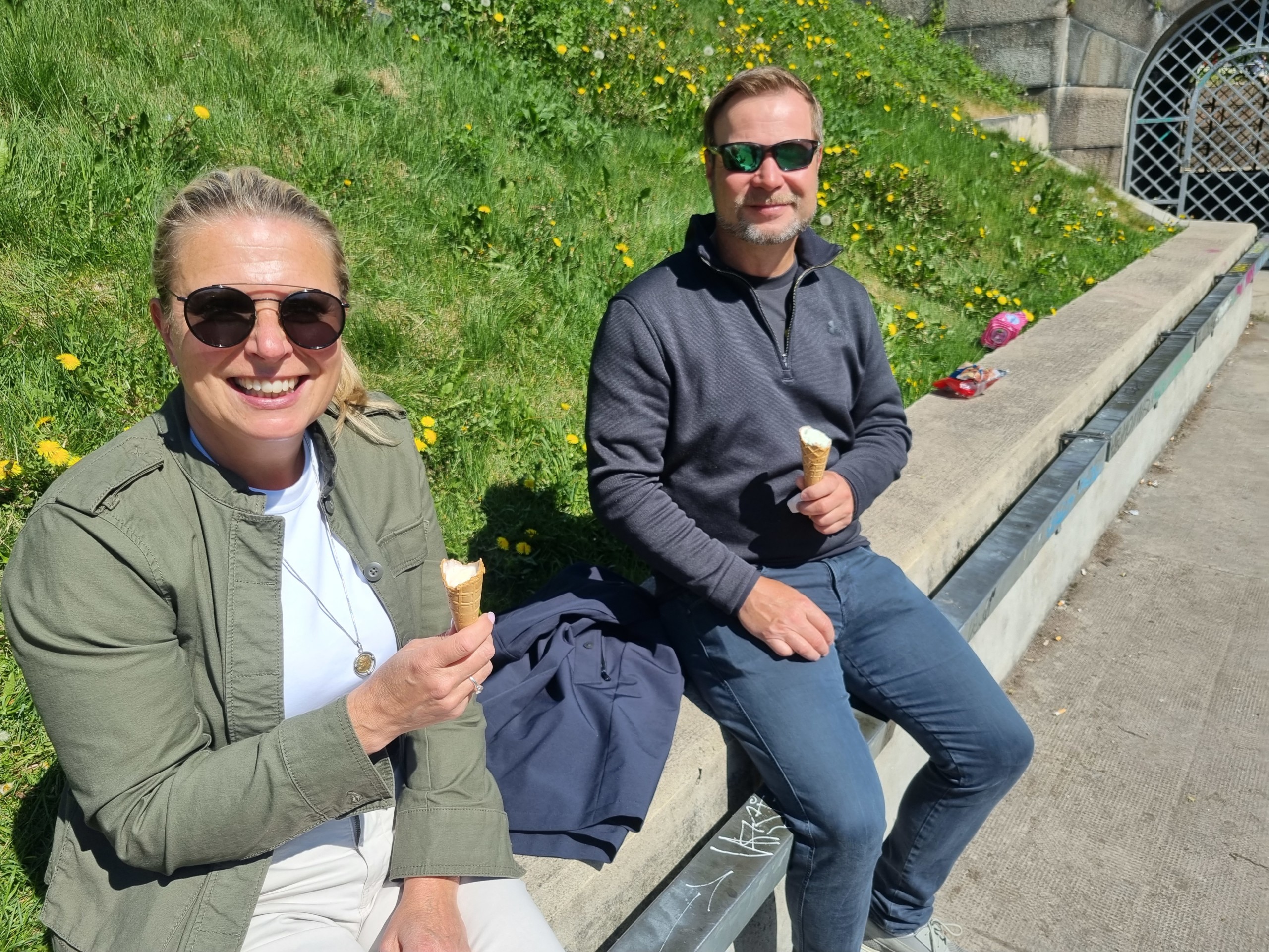 Ett medelålders par som sitter utomhus och äter glass