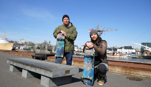 Två män vid skejtplats med skateboards.