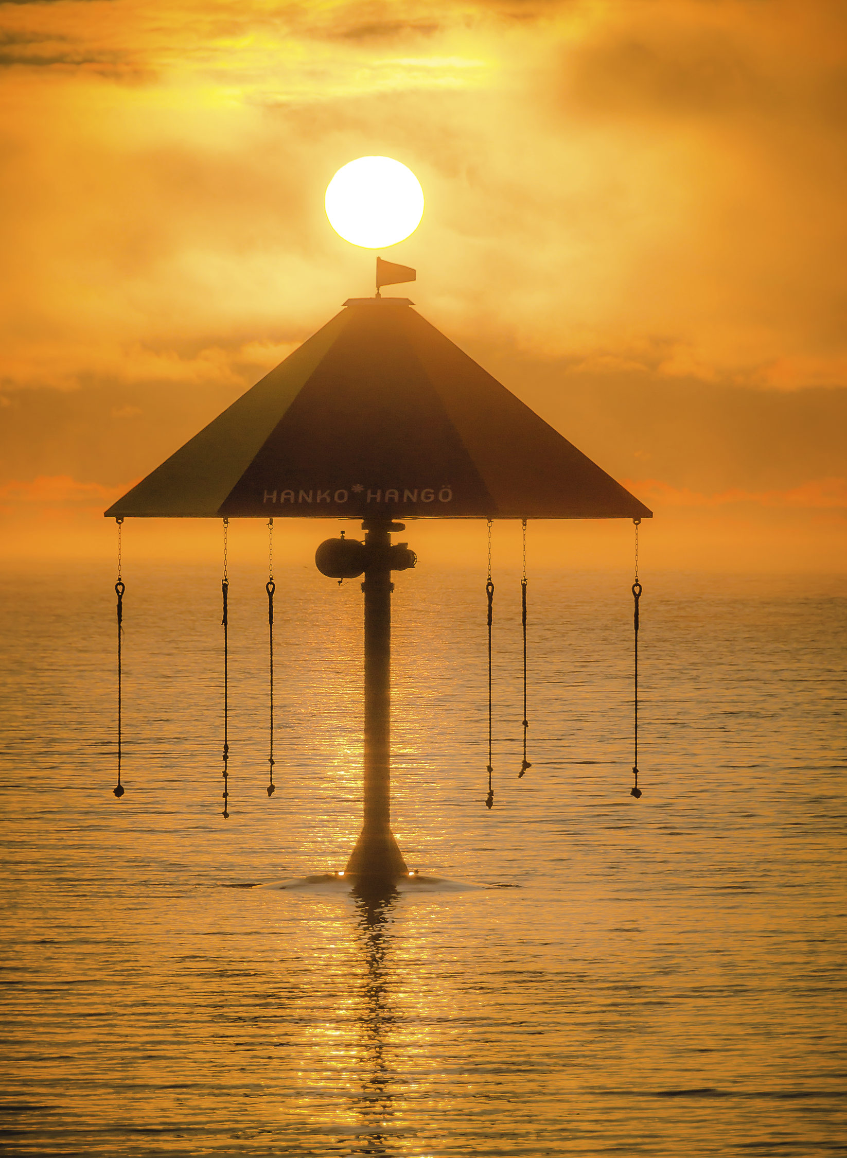 Havsvy i solnedgång med en karusell