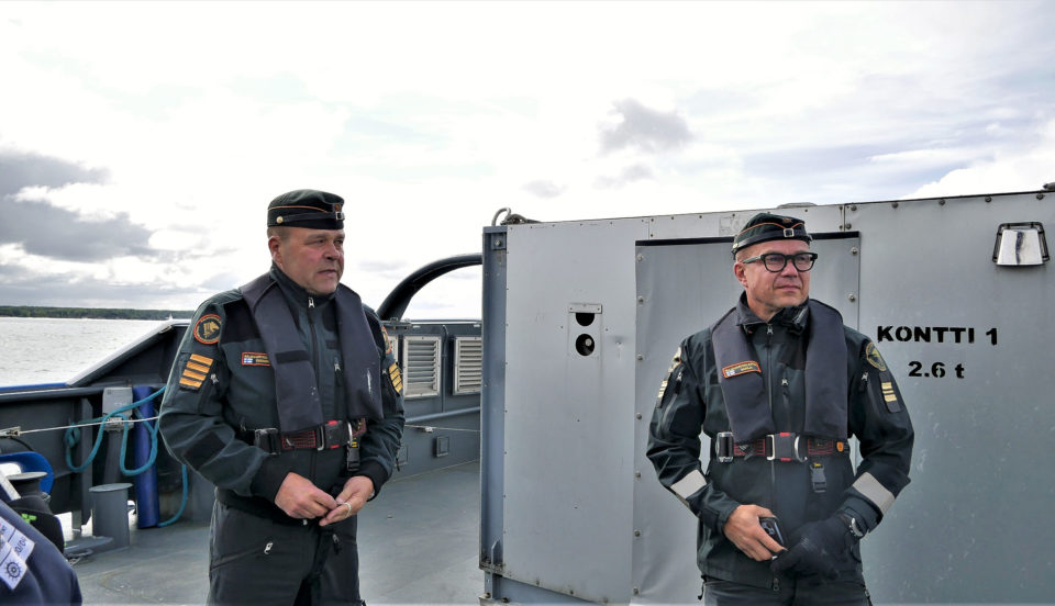 Två män står på sjöbevakningens fartyg.