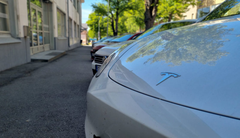 En Tesla och några andra parkerade bilar.