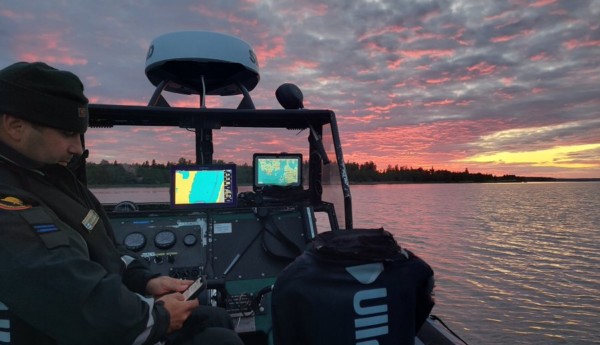 En patrullbåt i solnedgången med skärmar av olika slag ombord.