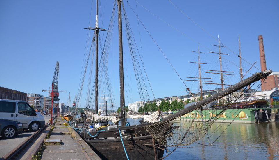 En stor, brun och gammal segelbåt står i Aura å.