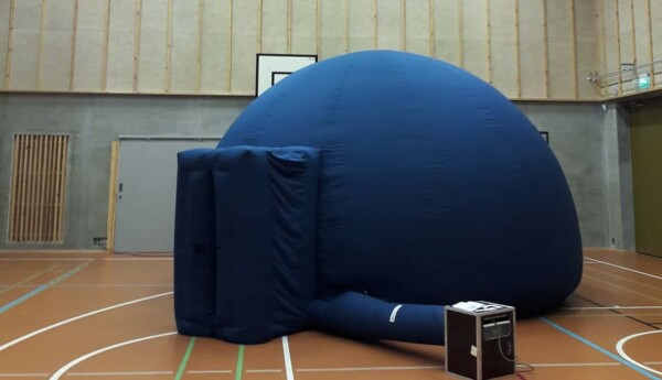 Ett blått kupolformat mobilt planetarium av tyg.