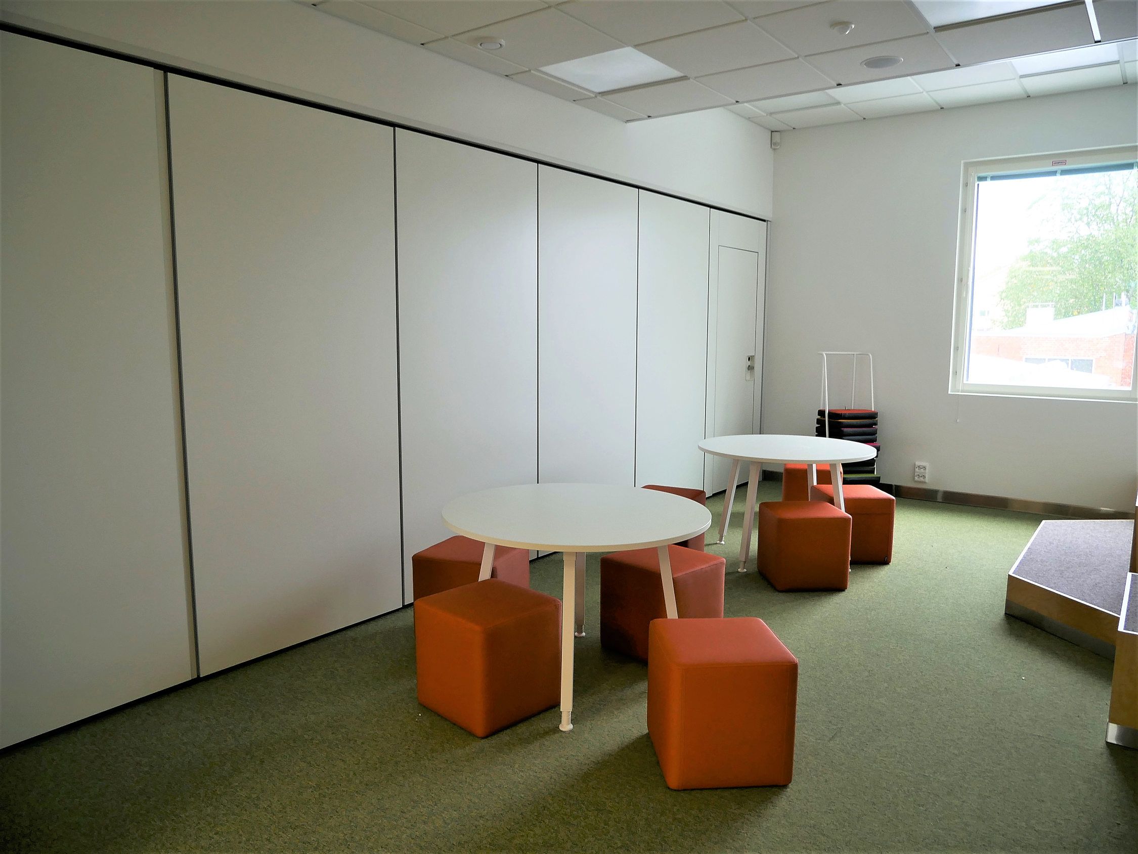 Rum med flyttbar vägg och bord och stolar.