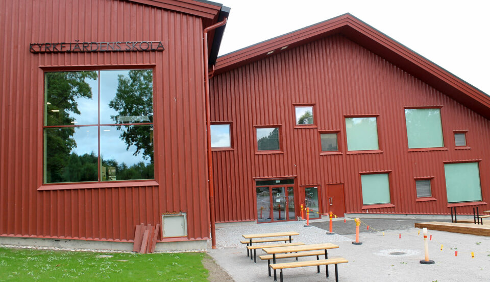 En stor röd skola fotad utifrån. Skolan finns i Ingå och byggnaden har flera fönster i olika storlekar och är byggd av trä.