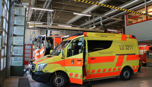 Bild tagen inne i Ekenäs brandstation. En ambulans är längst fram i bilden och i bakgrunden ser man en brandbil.