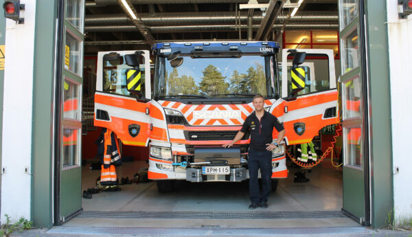 Brandförman Matias Söderblom står framför en brandbil i Ekenäs brandstation.