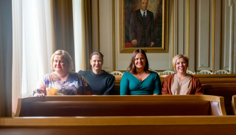 fyra kvinnor i en bänk i en fin sal
