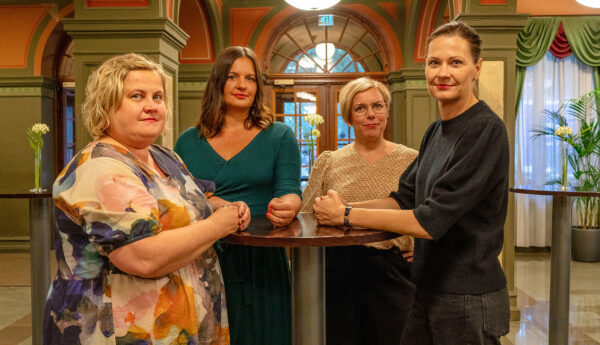 Fyra kvinnor står runt ett högt bord